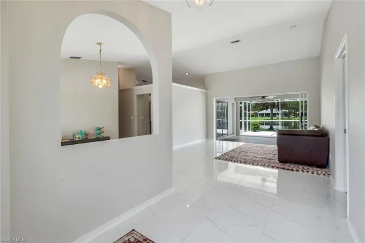 Hall featuring arched walkways and marble finish floors