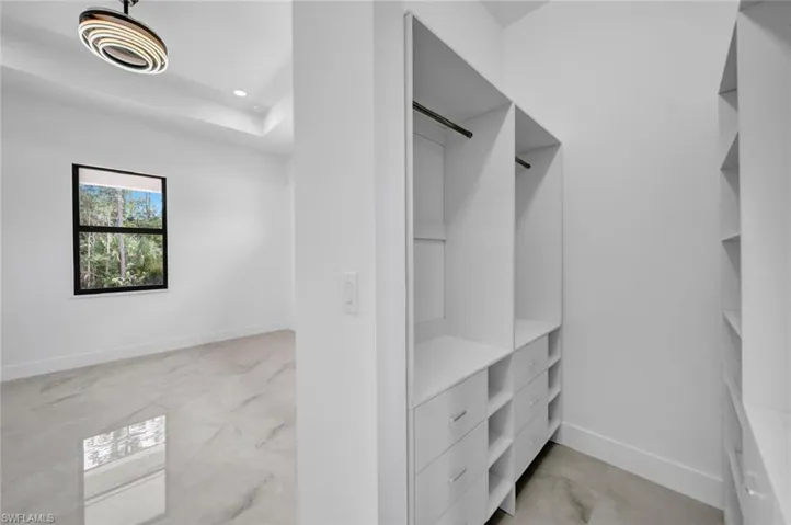 Walk in closet featuring marble finish floor