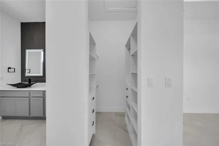 Spacious closet with a sink and marble finish floor