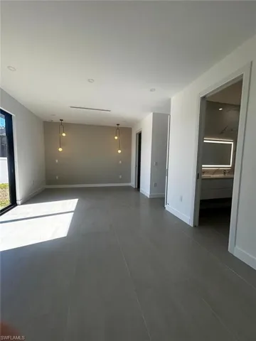 Spare room featuring baseboards and concrete flooring