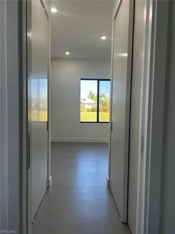 Corridor with recessed lighting and baseboards