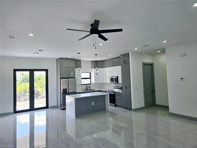 Kitchen featuring marble finish floor, modern cabinets, a kitchen island, appliances with stainless steel finishes, and gray cabinetry