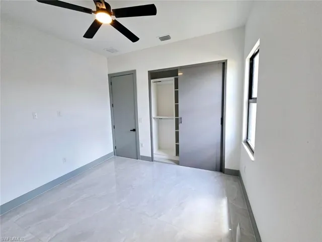 Unfurnished bedroom featuring baseboards, visible vents, a closet, and a ceiling fan