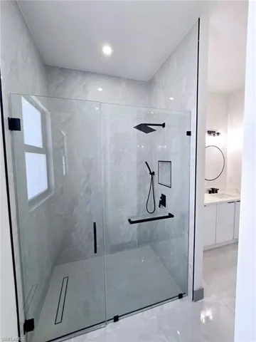 Full bath featuring a stall shower and vanity