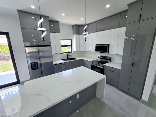 Kitchen with gray cabinets, a sink, appliances with stainless steel finishes, modern cabinets, and marble finish floor