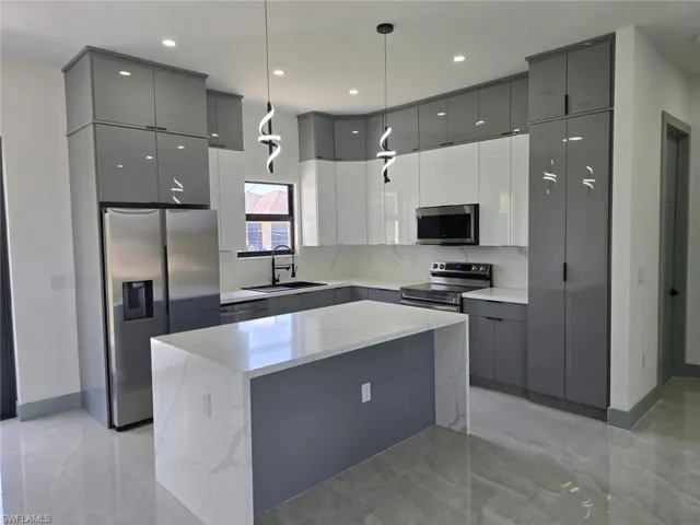 Kitchen with modern cabinets, gray cabinets, a sink, and stainless steel appliances