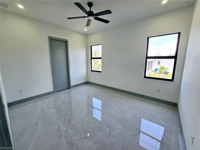 Spare room with marble finish floor, baseboards, visible vents, and recessed lighting