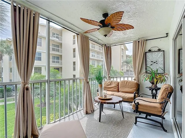 Sunroom / solarium featuring ceiling fan, a balcony, and a textured ceiling