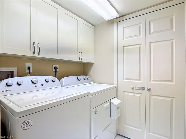 Laundry area featuring washing machine and dryer and cabinet space