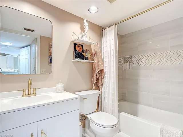 Guest bathroom with vanity and shower / tub combo with curtain