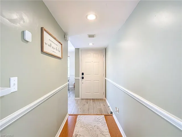 Doorway to outside with wood-type flooring and recessed lighting