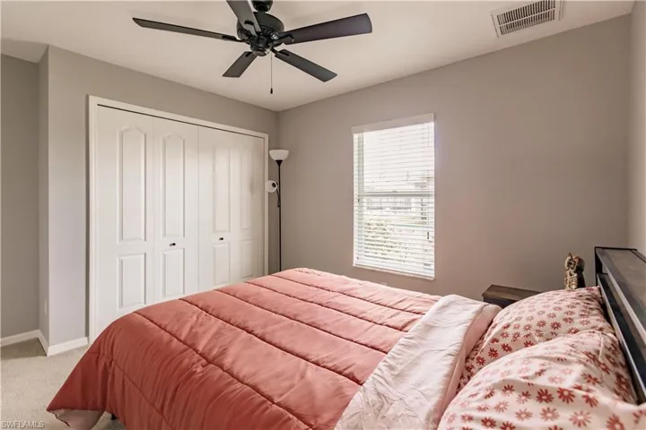 Carpeted bedroom with a closet and ceiling fan