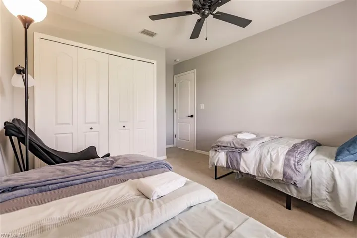 Bedroom featuring light carpet, a closet, and ceiling fan