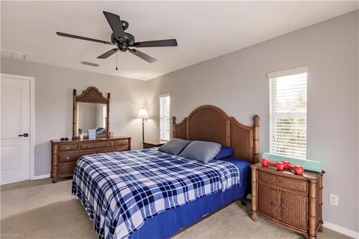 Carpeted bedroom featuring ceiling fan