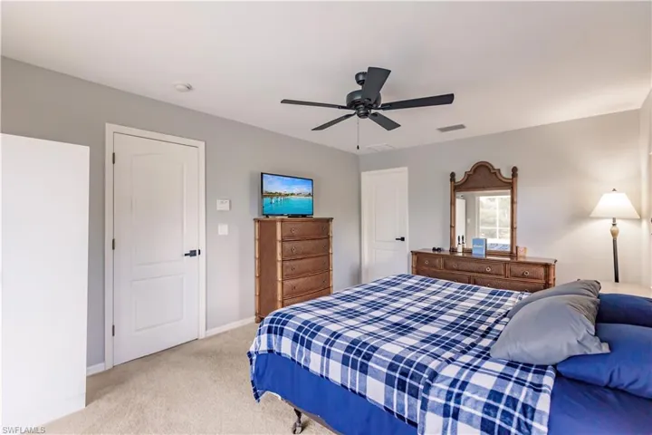 Bedroom featuring light colored carpet and ceiling fan