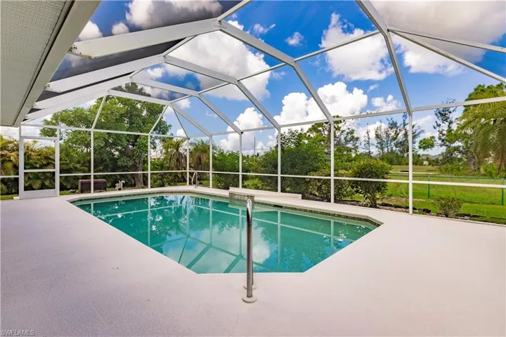 View of pool featuring a patio and glass enclosure
