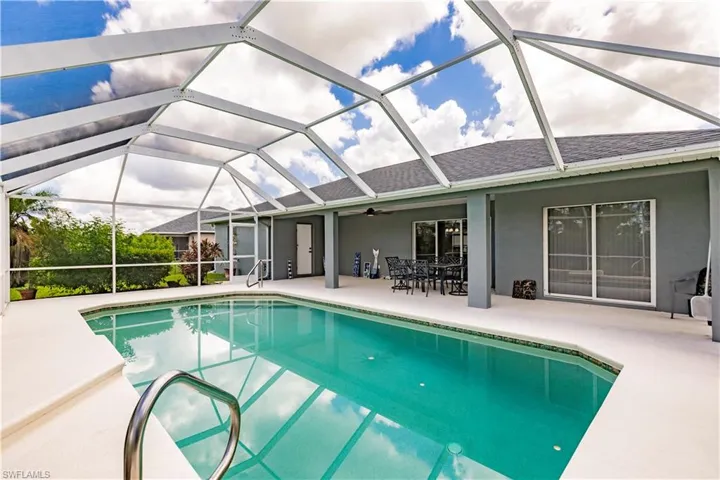View of swimming pool featuring ceiling fan, a patio area, and a lanai