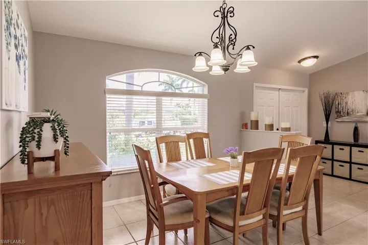 Dining area featuring a notable chandelier, light tile patterned flooring, and a wealth of natural light