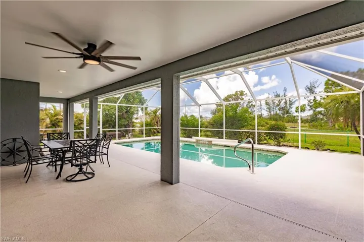 View of swimming pool with a lanai, a patio area, and ceiling fan