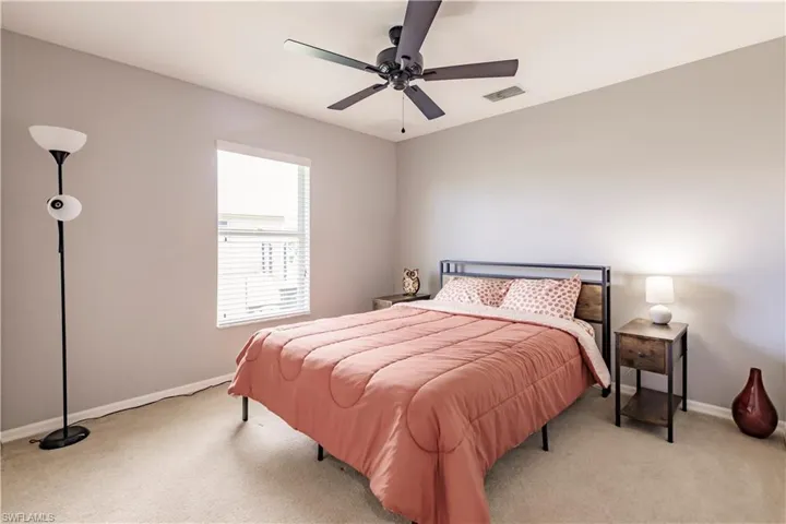 Bedroom featuring light colored carpet and ceiling fan