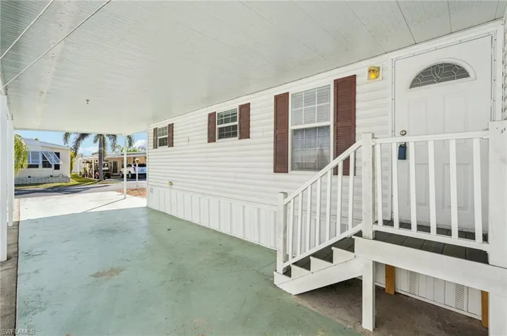 Property entrance featuring a carport and covered porch