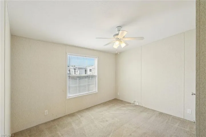 Unfurnished room featuring light colored carpet and ceiling fan