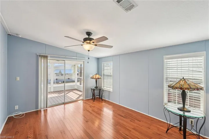 Spare room with ceiling fan, hardwood / wood-style flooring, and vaulted ceiling