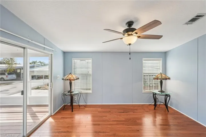 Unfurnished room featuring hardwood / wood-style floors, ceiling fan, and a textured ceiling
