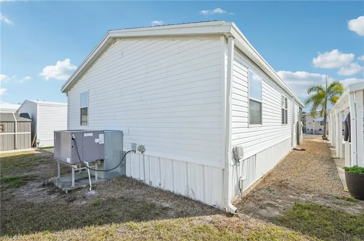 View of side of property with a shed and a central air condition unit
