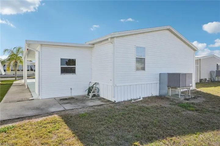 View of side of property featuring a yard and a patio