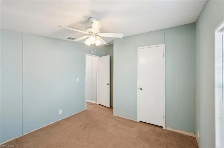 Unfurnished bedroom featuring light colored carpet and ceiling fan