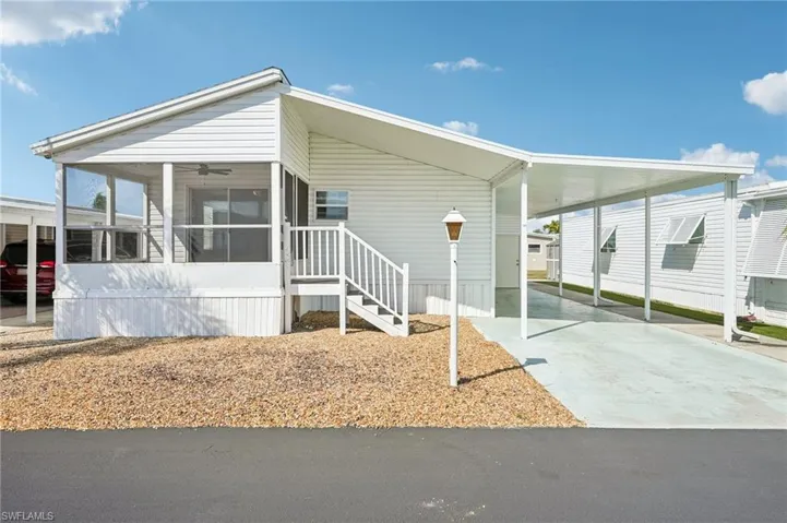 Manufactured / mobile home with a carport, a sunroom, and concrete driveway