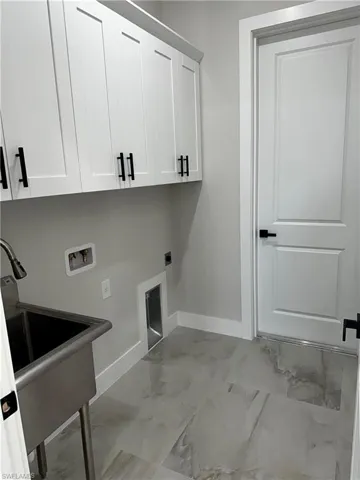Laundry room with hookup for a washing machine, cabinets, and hookup for an electric dryer