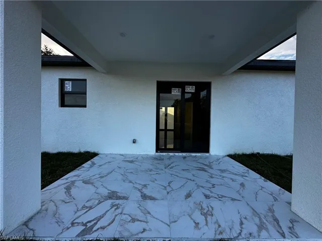 Bedroom with beamed ceiling and multiple windows