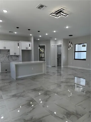 Kitchen featuring white cabinetry, a center island, and a healthy amount of sunlight