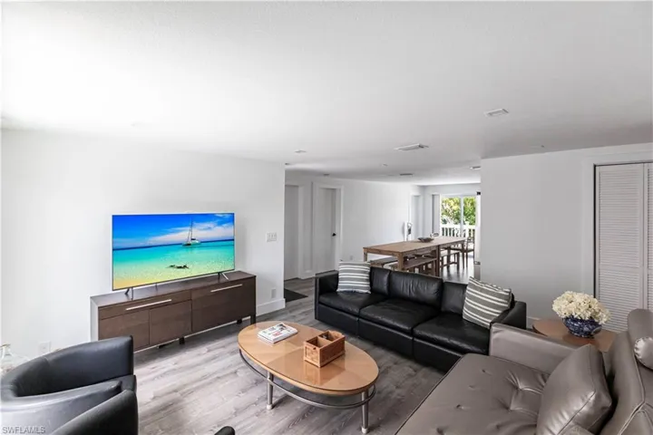Open-concept living space featuring wood-finish flooring, recessed lighting, and white walls