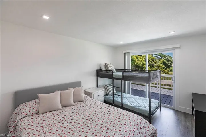 Bright room featuring recessed lighting, dark wood-finish flooring, and a sliding glass door opening to an outdoor deck