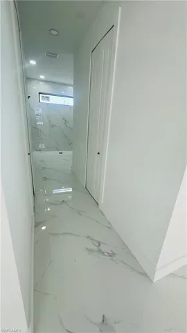 Corridor with baseboards and light marble finish flooring