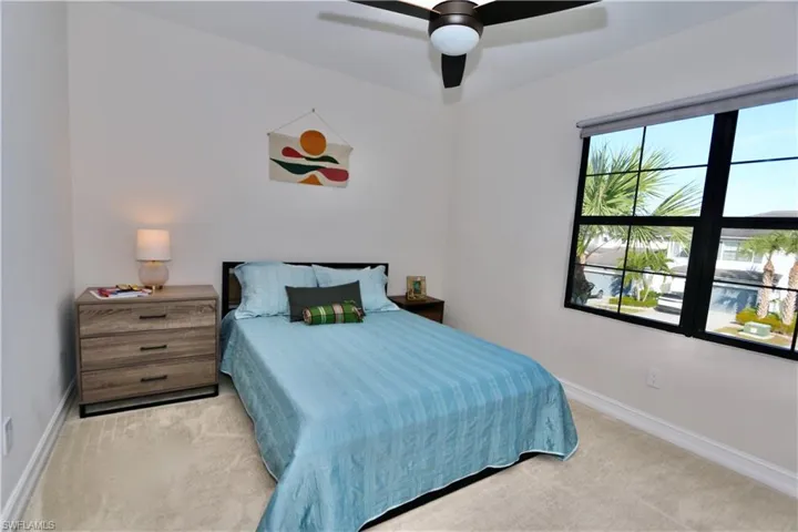 Bedroom with a ceiling fan and light colored carpet