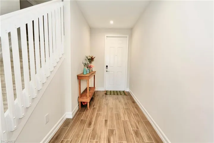 Doorway to outside featuring wood finish floors, stairs, and recessed lighting