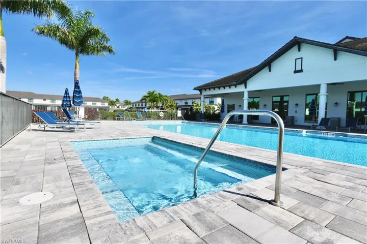 Community pool with a patio and a hot tub