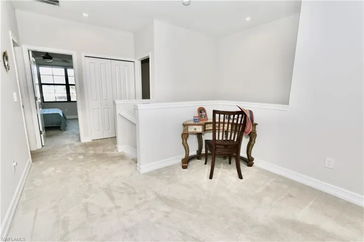 Living area featuring carpet, recessed lighting, and an upstairs landing