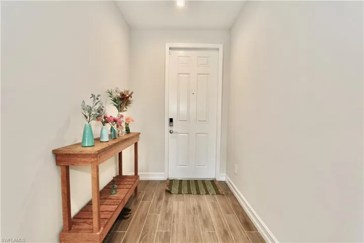 Doorway featuring wood finish floors and baseboards