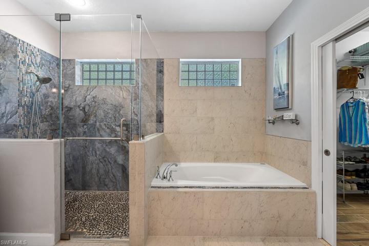 Soaking tub, and large shower with built in shelves, walk in closet