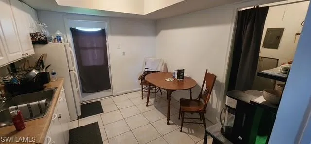 Dining room featuring light tile patterned floors and electric panel