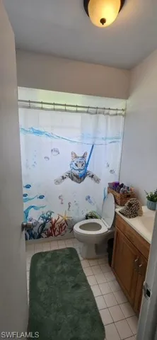 Full bath with vanity, tile patterned floors, and a shower with curtain