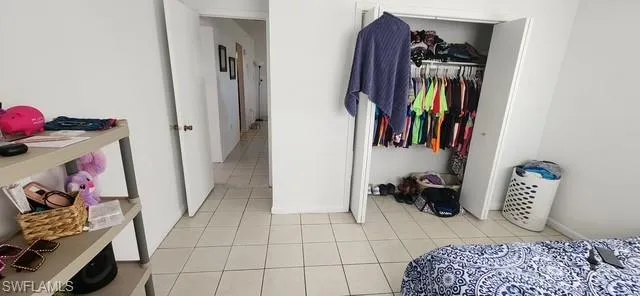Bedroom with light tile patterned floors and a closet