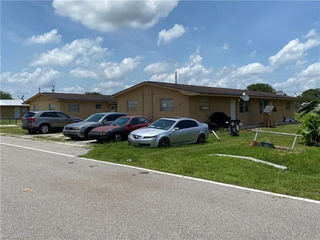 Single story home featuring a front yard and uncovered parking