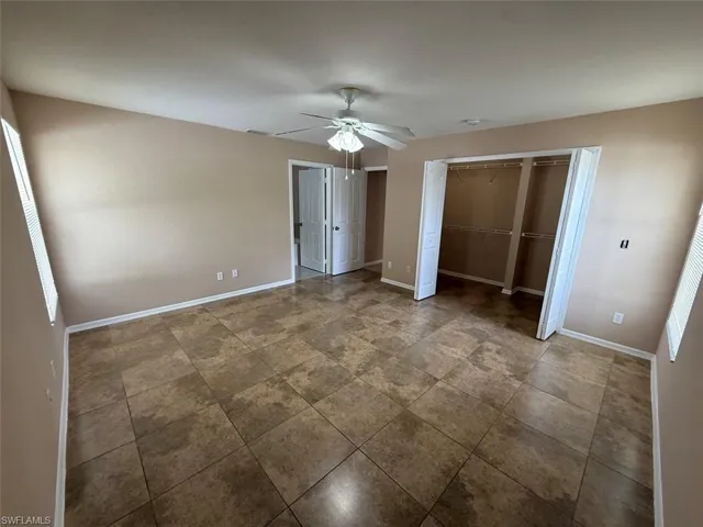Unfurnished bedroom featuring baseboards and ceiling fan