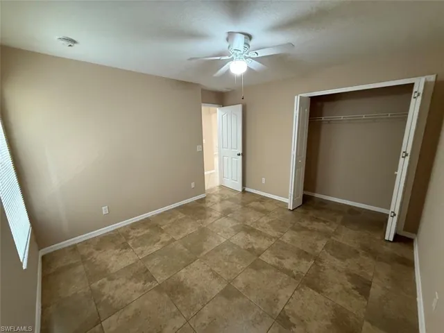 Unfurnished bedroom featuring baseboards, a closet, and ceiling fan